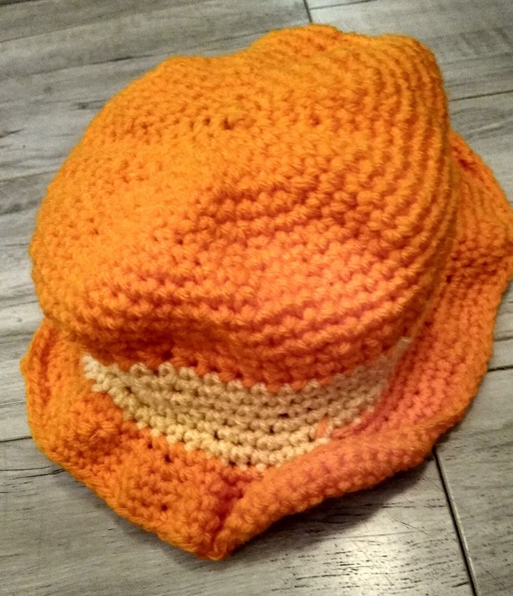 Crochet orange and yellow bucket hat is a small child's size 5 and a half inches. Casual Orange Crochet Beach Hat, Casual Orange Crochet Hat For Beach, Orange Crochet Beach Hat One Size, Fun Orange Hat With Curved Brim, Fun Orange Hats For Spring, Casual Orange Brimmed Hat, Fun Orange Curved Brim Hat, Handmade Casual Orange Crochet Hat, Casual Orange Bucket Sun Hat