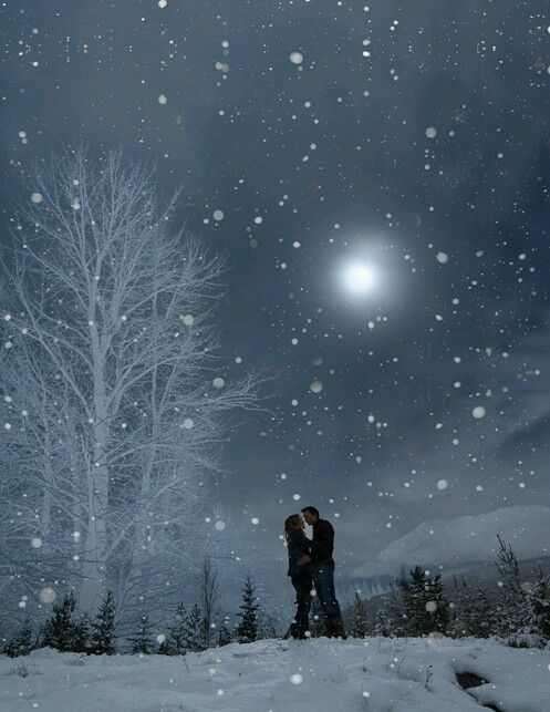 two people standing in the snow under a full moon with trees and sky behind them