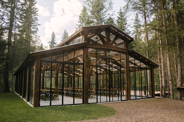 a large glass building in the middle of a forest