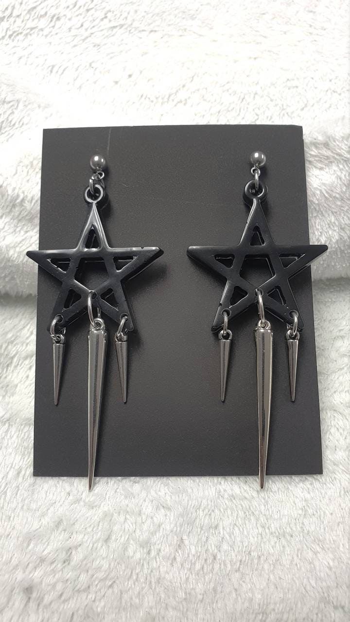 Looking for something with a witchy vibe? Then these black pentagram earrings are the right thing for you.  - Resin cast black pentagram, approximately 50 mm wide  - Buckles and studs are made of stainless steel, so they are suitable for those who are allergic to nickel  - Acrylic spike, 50 mm long  - Acrylic spikes, 24 mm long You can choose safety clips from stainless steel or silicone.  You can fit them into any outfit and these are some of the ideas: They will look great on a tight gothic dress, a wide grunge vest or a shirt. Complete your witchy Wiccan with these beautiful earrings.  I am at your service for all information.  Thank you for your interest in my work and support.  Follow me on the social networks listed below.  Facebook: www.facebook.com/KalitheaAlternativeAccessories  I Black Gothic Earrings, Black Metal Earrings For Alternative Fashion, Black Punk Earrings For Alternative Fashion, Black Metal Grunge Earrings, Black Edgy Dangle Earrings, Edgy Black Dangle Earrings, Black Pierced Earrings For Alternative Fashion, Black Earrings For Alternative Fashion, Black Punk Metal Earrings