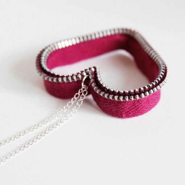 two pink bracelets with silver chains hanging from the ends on a white surface,