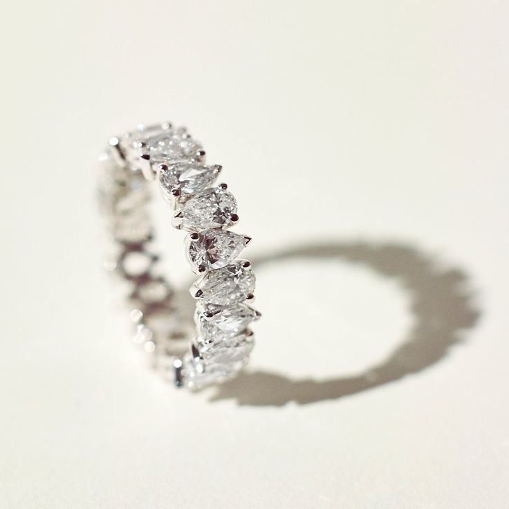 a diamond ring is shown on a white surface with the shadow from it's reflection