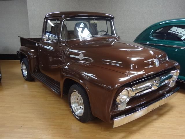 an old pickup truck is parked in a showroom