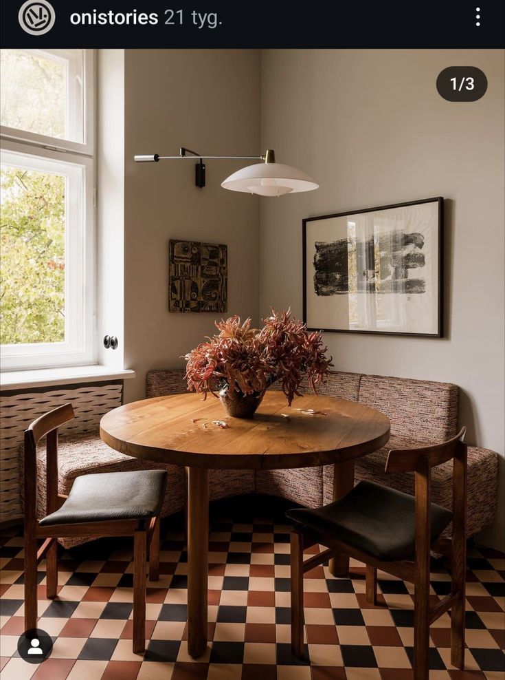 a wooden table sitting under a window next to a bench with chairs on top of it