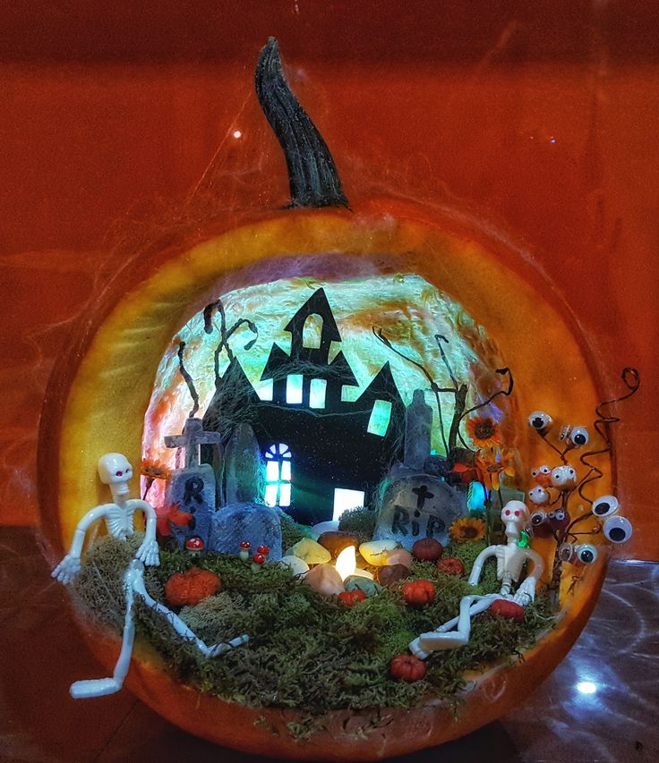 a pumpkin decorated with skeletons and houses