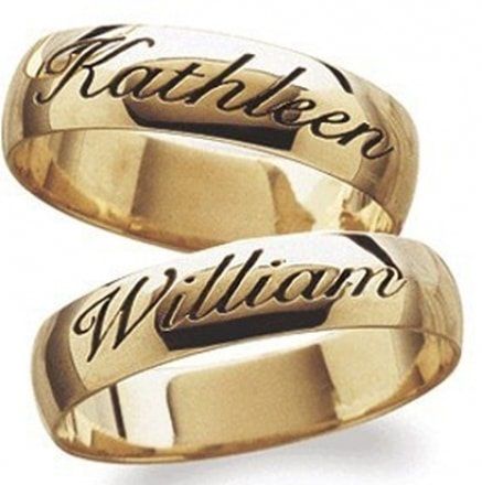 two gold wedding rings with names engraved on them