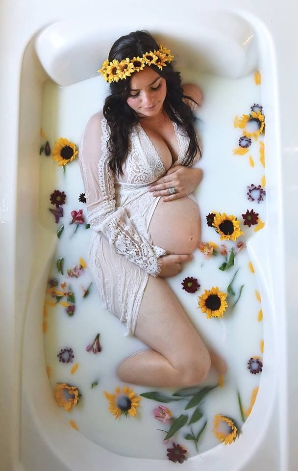 a pregnant woman in a bathtub with sunflowers