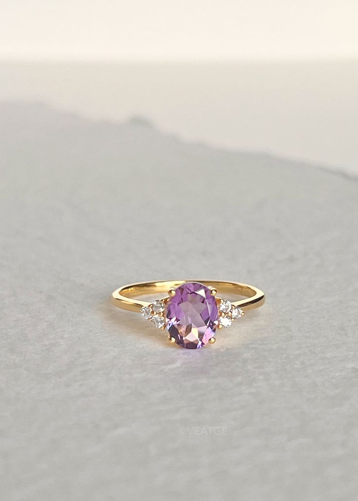 Our Fleur Amethyst ring features a single soft purple faceted Amethyst stone set in a sturdy four-prong setting surrounded with three white topaz on each side. It can be worn as an engagement ring and a statement ring stacked with our Colline and Hana ring for a unique look. Always handmade with genuine and natural stones on solid sterling silver and thick gold vermeil that will stand the test of time. D E T A I L S * Materials - 18k gold vermeil on solid 925 sterling silver, genuine faceted Ame Timeless Purple Rings As Gifts, Timeless Purple Rings Perfect For Gifts, Timeless Purple Rings For Gifts, Minimalist Gold Amethyst Ring, Modern Purple 14k Gold Jewelry, Timeless Amethyst Ring As A Gift, Minimalist Jewelry With Center Stone, Minimalist Amethyst Birthstone Ring For Anniversary, Minimalist 14k Gold Amethyst Ring As Gift