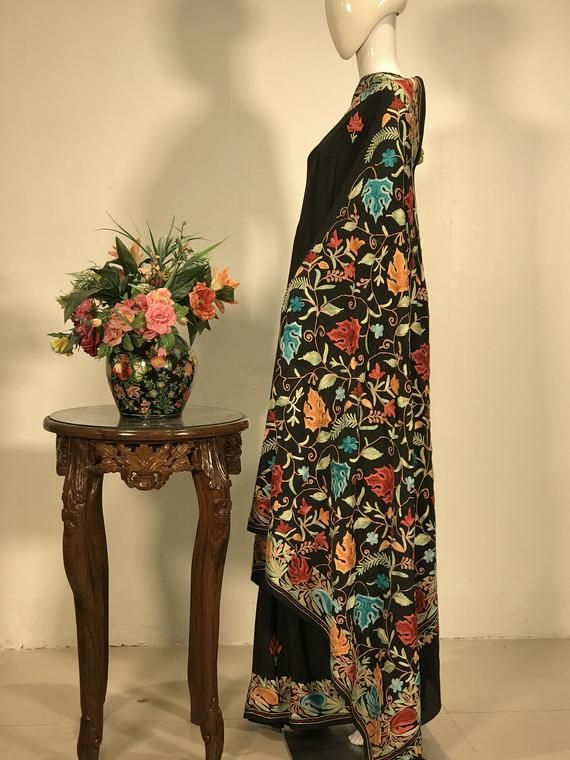 A Marvellous Embroidered Kashmiri Saree which you can wear at any party or a wedding.- - - - - - - - - - - - - - - - - - - - Product Details- Condition: Brand New (made to order)- Style: Saree Dress- Embroidery: All-over Kashmiri Aari Embroidery.- Base Colour: Black- Embroidery Colour: Multi-colour- Care Instructions: Dry Clean OnlyF A B R I CSaree: Viscose GeorgetteBlouse: Indian CrepeF I N I S H- UnstitchedYou can get it stitched locally.- StitchedWant your blouse ready to wear, let us know th Traditional Floor-length Dress With Chikankari Embroidery, Designer Multicolor Embroidered Traditional Dress, Designer Bollywood Embroidered Saree Dress, Bollywood Style Designer Embroidered Saree Dress, Bohemian Embroidered Dress With Zari Work For Wedding, Bohemian Wedding Dress With Zari Work, Designer Embroidered Saree With Zari Work, Multicolor Embroidered Zari Work Dress For Wedding, Multicolor Embroidered Dress For Wedding And Festive Occasions