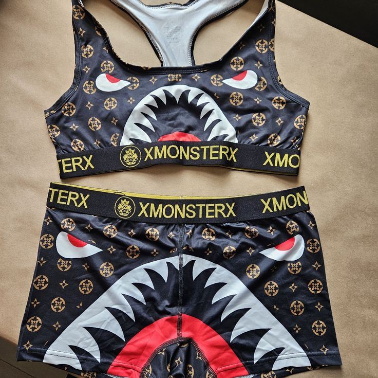 This Xmonsterx Grappling Women's Set In Size Large Is Perfect For Mma And Sports Enthusiasts. The Set Includes A Black Bra And Shorts Made From A Blend Of Polyester And Spandex Fabric That Provides Comfort And Flexibility During Intense Workouts. The Fangs Pattern And Sports Theme Add A Touch Of Style To The Set, Making It Perfect For Activewear. The Two-Piece Set Is Suitable For Women Of All Sizes And Is Not Vintage. The Brand Is Xmonsterx And The Set Is Categorized Under Clothing, Shoes & Acce Fitted Black Sets With Letter Print, Black Sporty Sets With Graphic Print, Sporty Black Sets With Graphic Print, Black Stretch Sets With Letter Print, Black Graphic Print Sets For Streetwear, Trendy Black Sets With Graphic Print, Trendy Black Graphic Print Sets, Trendy Black Graphic Print Set, Grappling