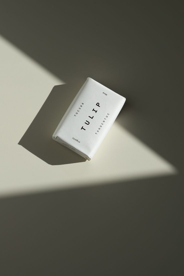 a book sitting on top of a white table next to a shadow from the wall