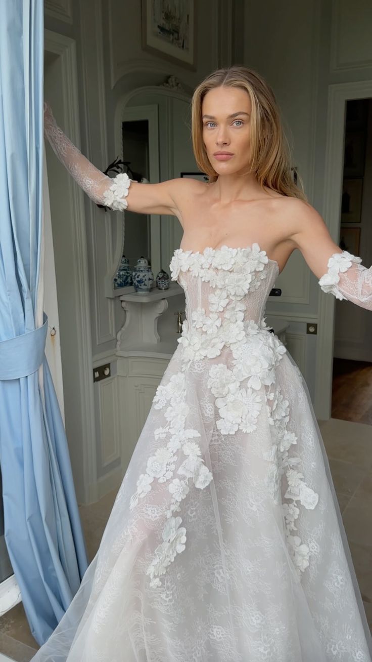 a woman in a white wedding dress posing for the camera