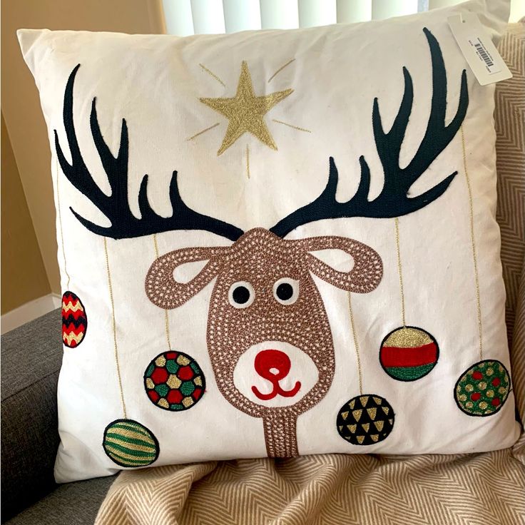 a reindeer pillow with christmas ornaments on it