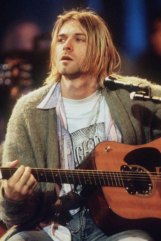 a man holding a guitar with a red heart on it