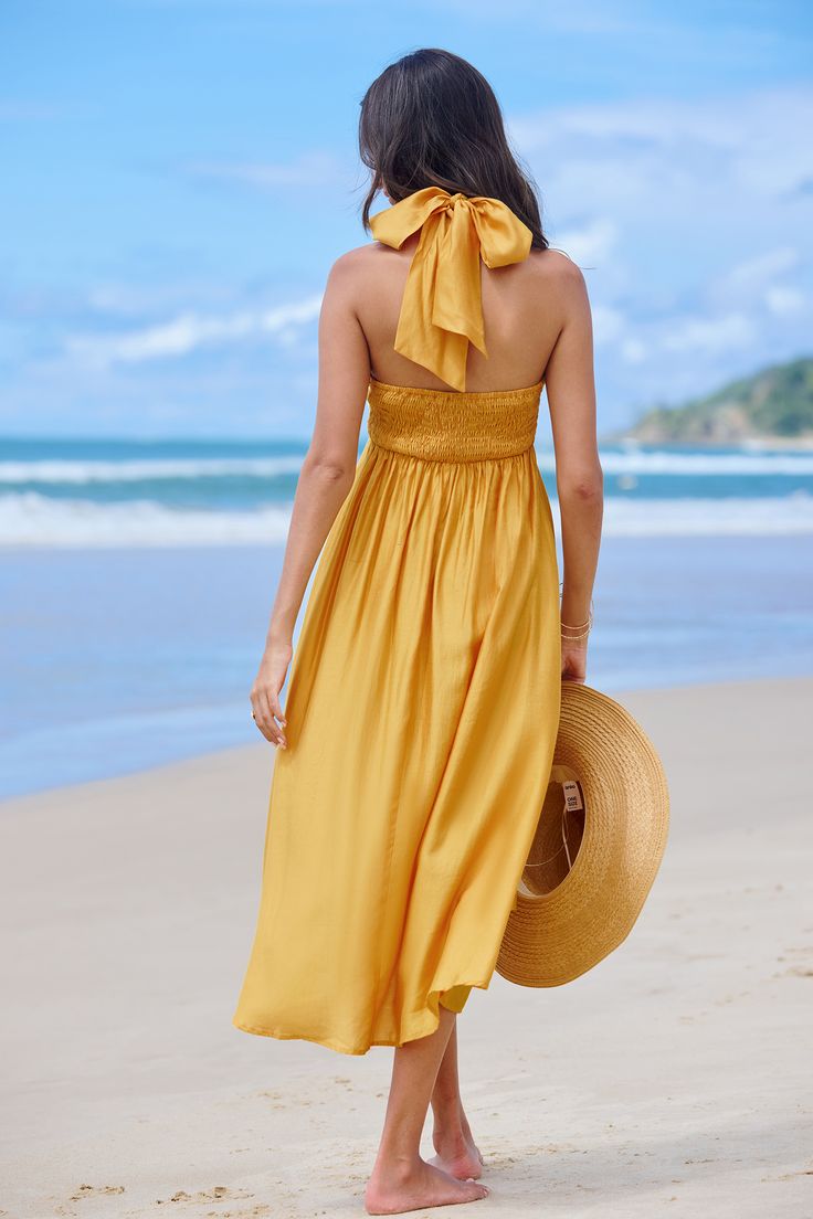 The Sunflower Yellow Halterneck Midi Dress radiates summertime charm with its vibrant hue and flattering design, making it the perfect choice for sunny days and outdoor events. Product code: CAA05A4C139NN Features:  Woven Halter neckline Sleeveless Midi Wash Method: Regular Wash Material: 80%RAYON,20%POLYESTER. Summer Garden Party Beachwear Midi Dress, Vacation Sundress For Garden Party, Summer Style Maxi Dress With Smocked Back, Summer Beach Sundress With Smocked Back, Summer Maxi Dress With Smocked Back For Garden Party, Summer Garden Party Dress With Smocked Back, Summer Beachwear Dress For Garden Party, Yellow Tie-back Dress For Vacation, Sleeveless Dresses For Garden Party Vacation