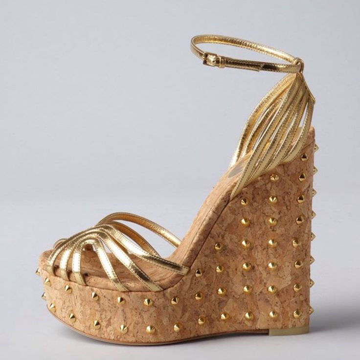 Elevate your style with these stunning Gold Metallic Wedge Sandals. Featuring a peep toe design, strappy details, and studded platform heels, these sandals are perfect for adding glamour to any outfit. Color: Gold Material: Metallic finish Heel Type: Wedge heel Heel Height: 5.5" / 140 mm approx Product measurements were taken using size 8. Please note that measurements may vary by size Toe: Peep toe Adjustable ankle strap design Gold stud embellishment Handcrafted US sizing. Fits true to size. Summer Spiked Open Heel Heels, High Heel Sandals With Spikes For Spring, Chic Spiked Sandals For Summer, Luxury Open Heel Platform Wedge Sandals, Summer Party Heels With Gold Studs, Party Open Toe Sandals With Gold Studs, Party Sandals With Gold Studs And Open Toe, Luxury Open Toe Wedge Sandals, Luxury Gold Platform Wedge Sandals