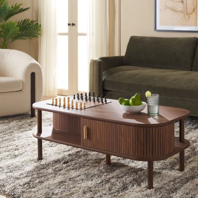 a living room filled with furniture and a chess board on top of a coffee table