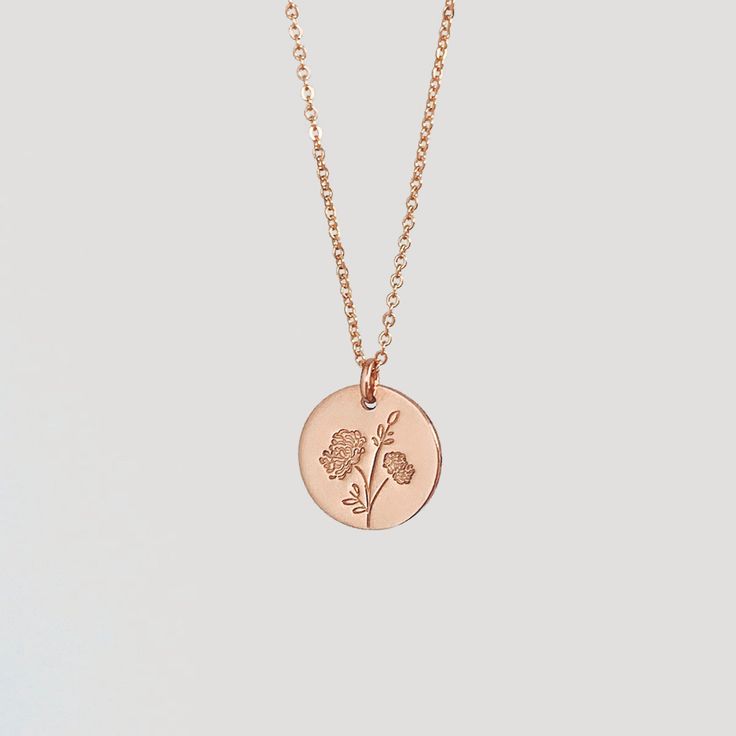 a gold necklace with a flower on it