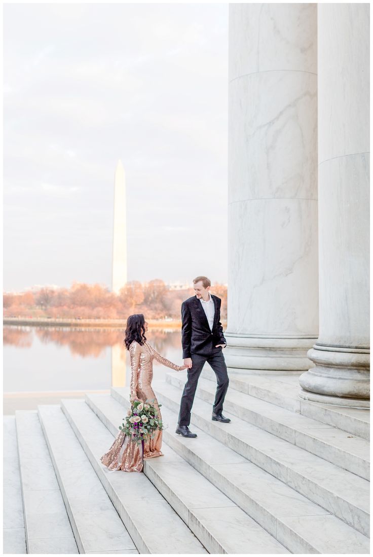 an engaged couple holding hands on the steps of the lincoln memorial