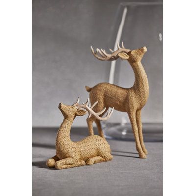 two deer figurines sitting next to each other