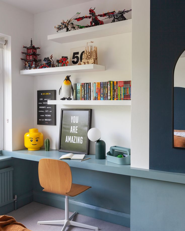 a desk with a chair, bookshelf and pictures on the wall above it