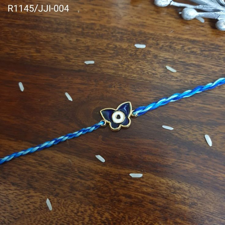 a blue and white string with an evil eye on it sitting on a wooden table