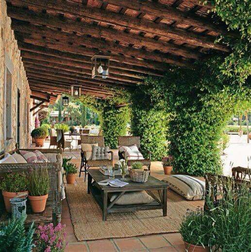 an outdoor covered patio with potted plants and furniture