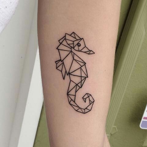 a small black and white seahorse tattoo on the right arm, with geometric shapes