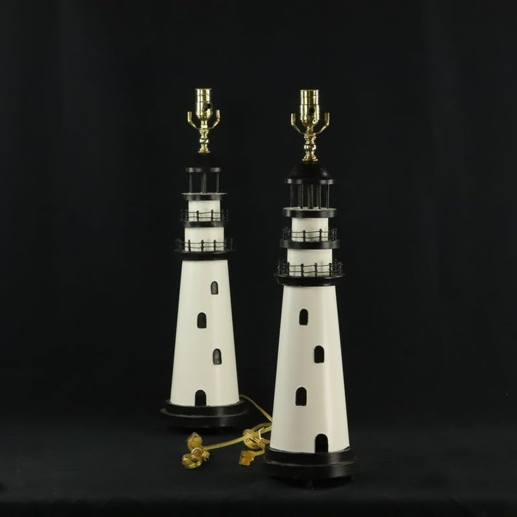 two white and black lighthouses with gold trophies on top of each one in front of a black background