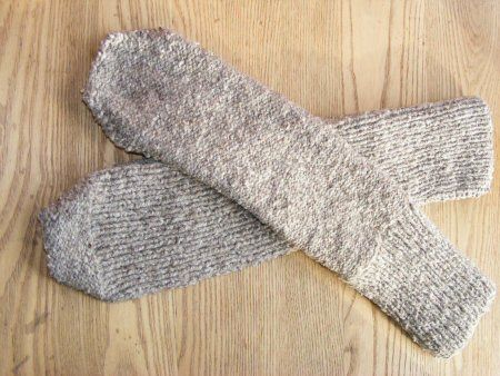 two gray socks laying on top of a wooden floor