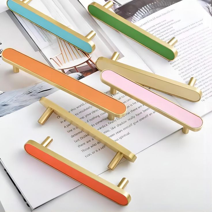 four different colored hair clips sitting on top of an open book next to each other