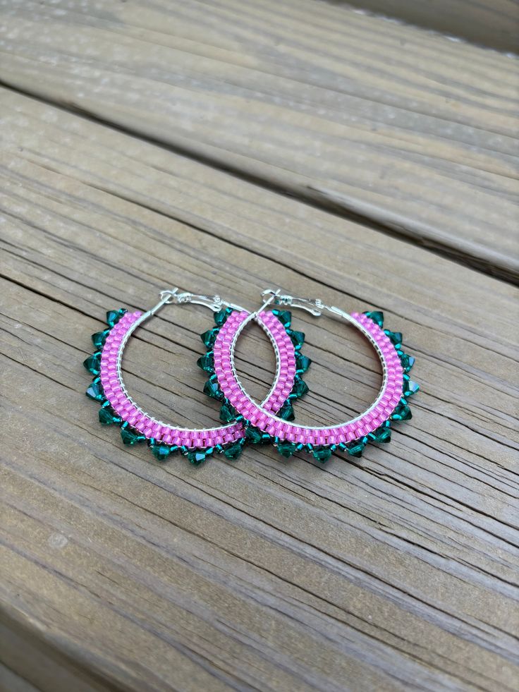 These earrings are made with pink and teal Toho seed beads and emerald Preciosa Crystals. The size of the hoops is 40mm. Handmade Green Beaded Hoop Earrings, Beaded Pink Hoop Earrings For Beach, Pink Beaded Hoop Earrings For Beach, Pink Hoop Earrings For The Beach, Bohemian Round Pink Beads, Bohemian Pink Round Beads, Pink Dangle Beaded Earrings With Spacer Beads, Pink Spacer Beads For Crafting, Bohemian Pink Earrings With Spacer Beads