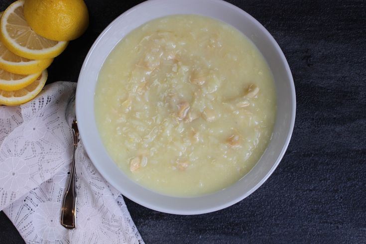 a bowl of soup with lemons on the side