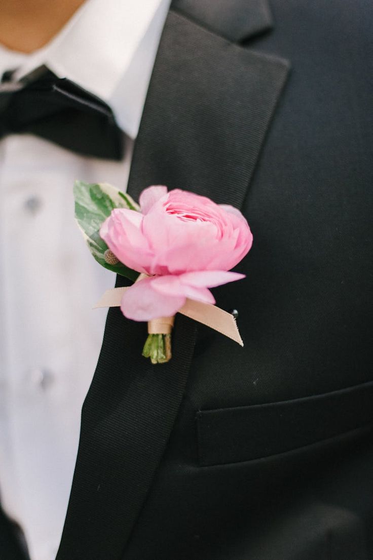 a man in a tuxedo with a pink flower on it's lapel