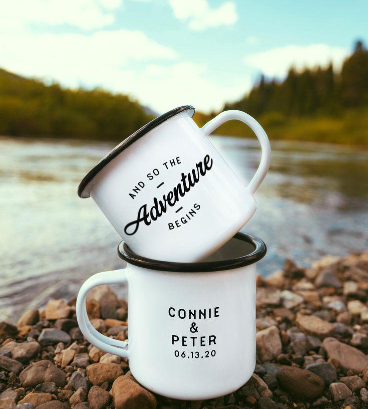 two white coffee mugs sitting on top of rocks