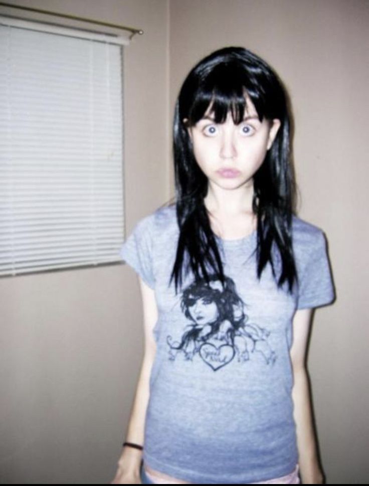 a girl with long black hair wearing a t - shirt