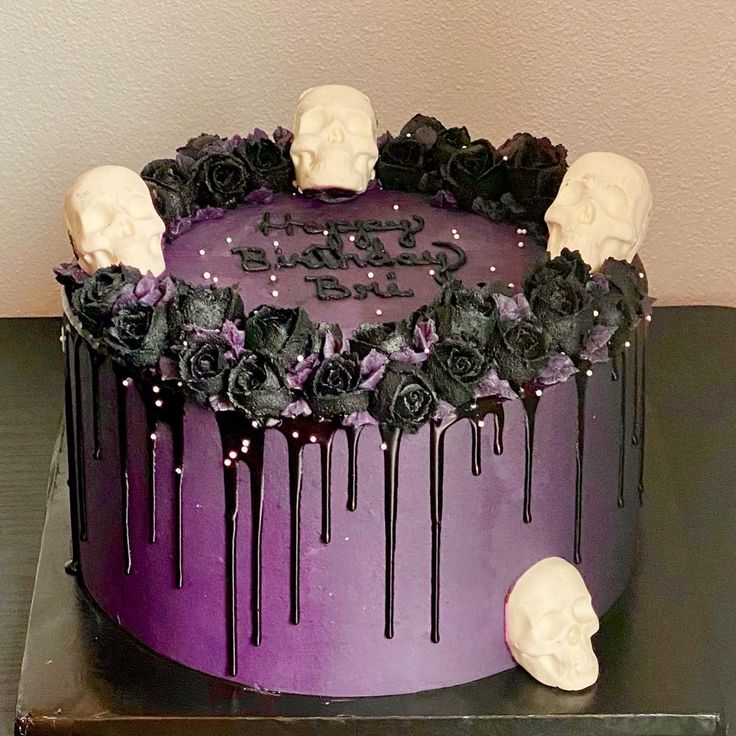 a purple cake with skulls and roses on the top is decorated with black icing