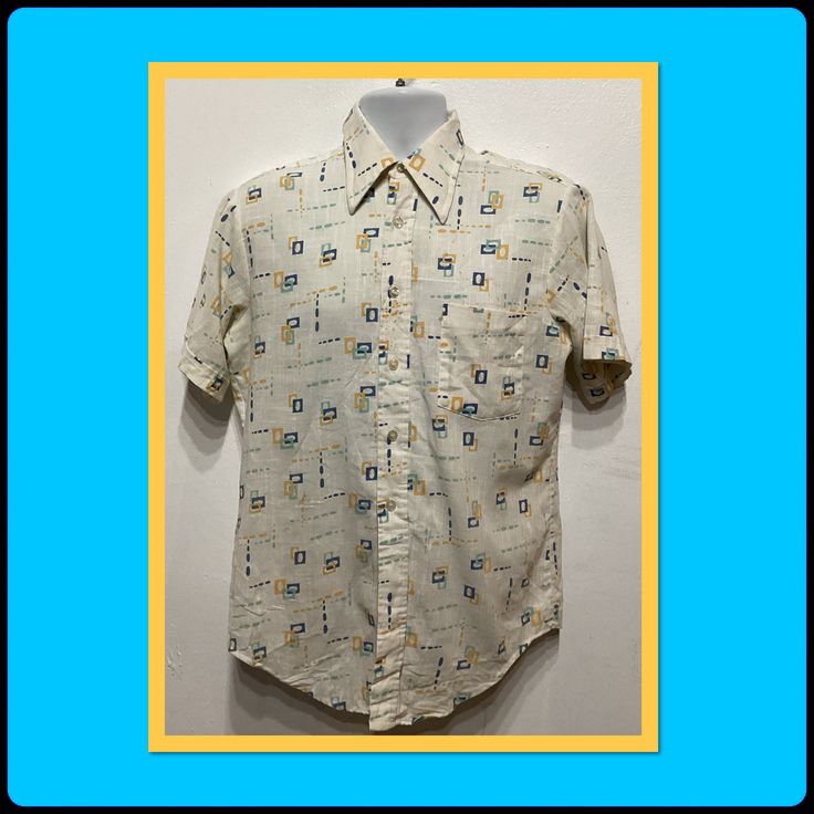 1970s printed shirt by Kmart. Size medium 15-151/2. The cotton blend shirt has a white base color with an abstract design in shades of blues & mustard yellow. The shirt has a pointed loop collar, five button down front, short sleeves and one patch pocket. The shirt is in vintage condition.  Please see small  stains that may or may not wash out. The label states K-Mart perm press 50% cotton 50% polyester Size medium 15-15 1/2. Please see measurements for proper fit.  MEASUREMENTS: (All measurements were taken lying flat) Shoulders -17'' (measured on back of the shirt from seam to seam) 22" (measured from pit to pit) Sleeve- 9.5"  (measured from shoulder to cuff) Sleeve- 5" (measured from pit to cuff) Length - 31" (measured on back of shirt from top of collar to the bottom hem) Cuff Sleeves, Mustard Yellow, Base Colour, Button Downs, Shades Of Blue, Abstract Design, 1970s, Cotton Blend, Short Sleeves