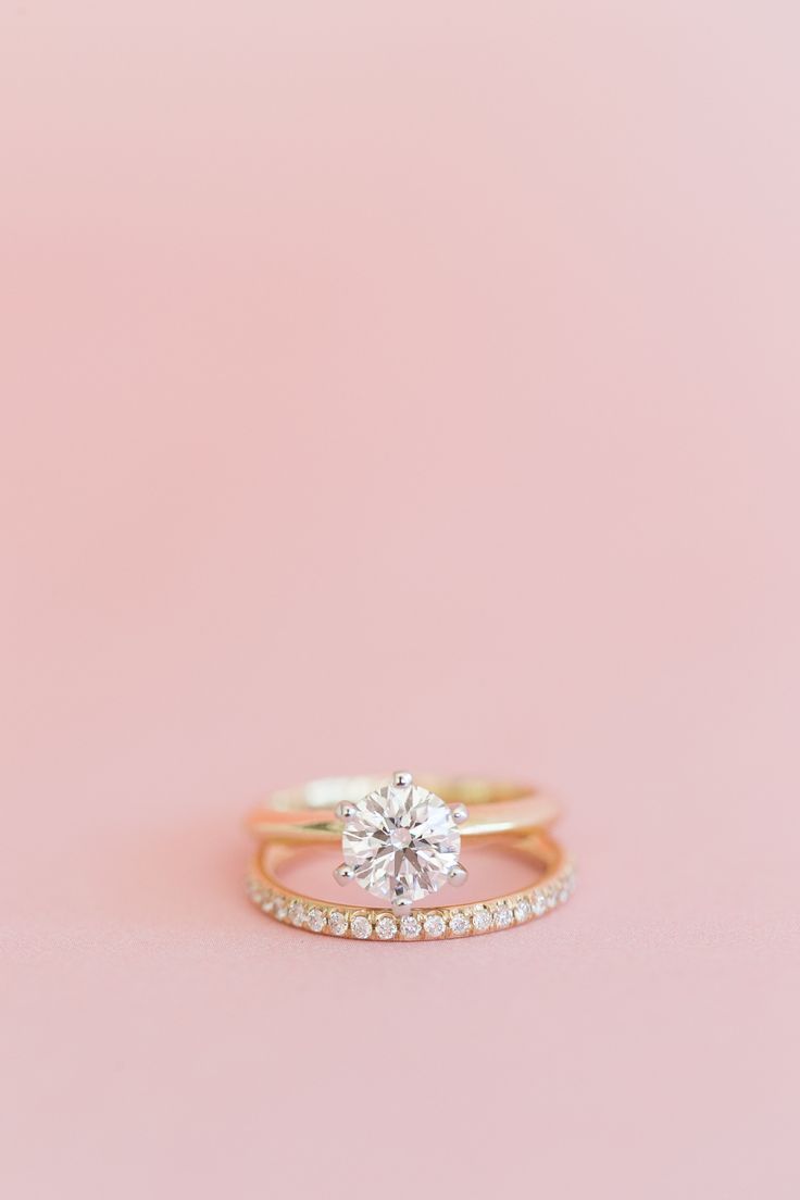 a close up of a diamond ring on a pink background