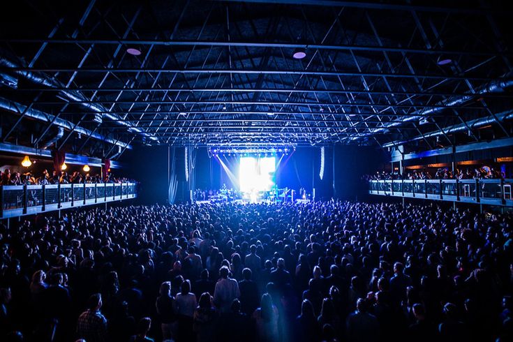 a large group of people standing in front of a stage