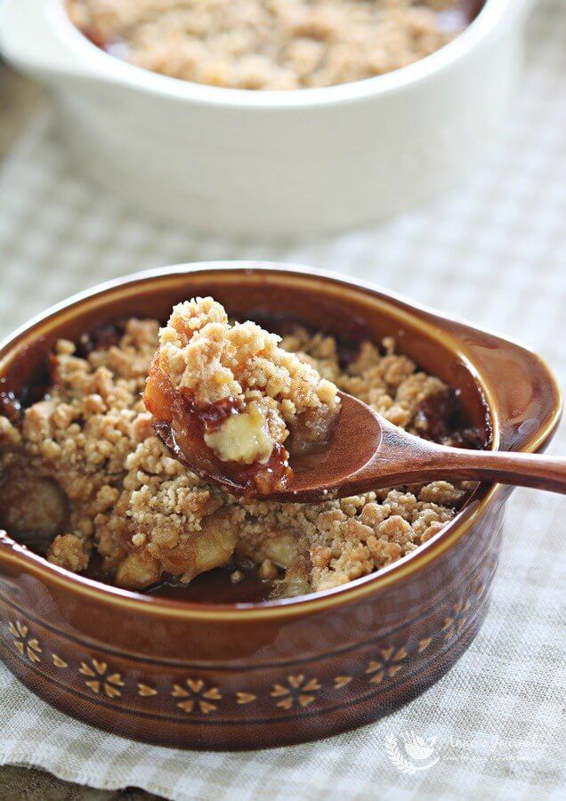 a spoonful of oatmeal is in a bowl with another bowl full of oatmeal