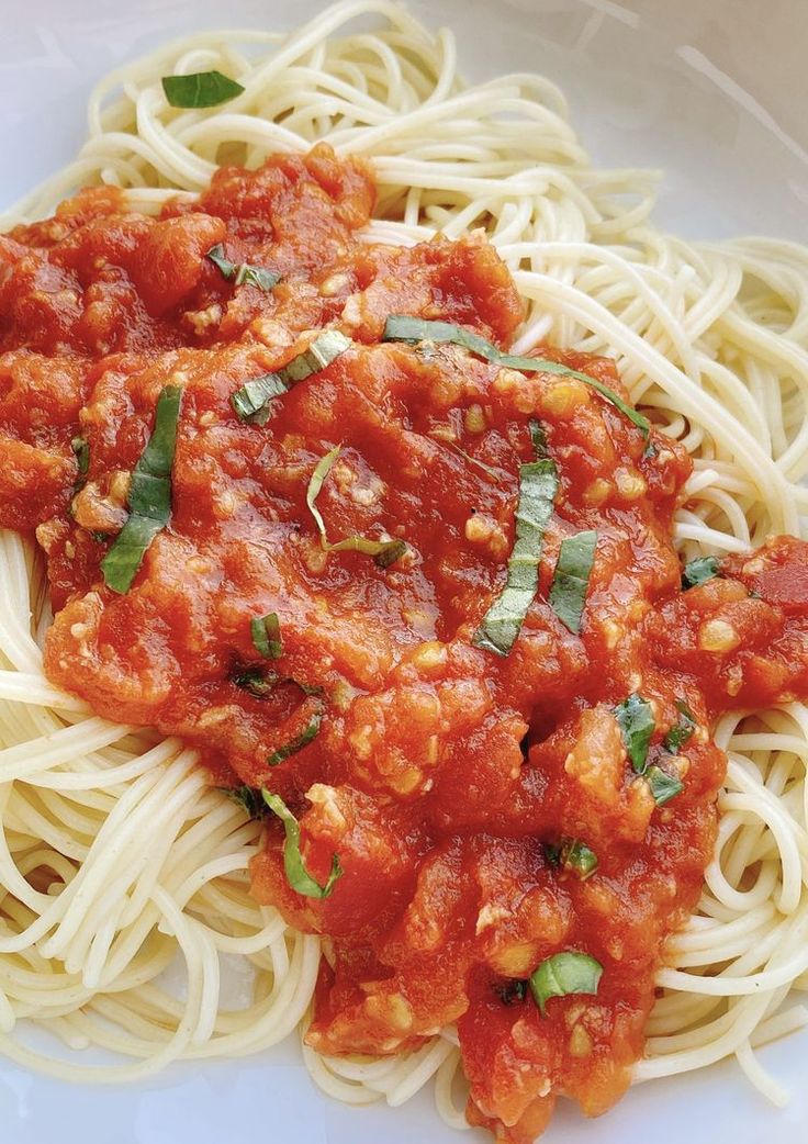 spaghetti with tomato sauce and basil leaves on top