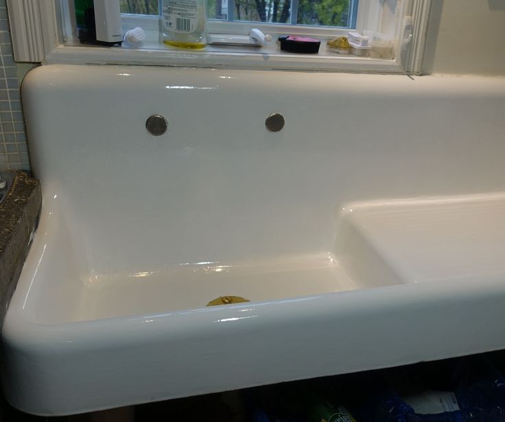 a white sink sitting under a window in a bathroom