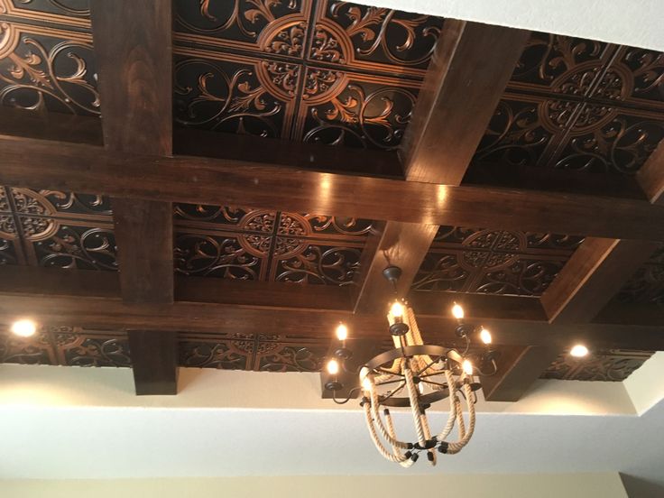 a chandelier hanging from the ceiling in a room with wood paneled ceilings