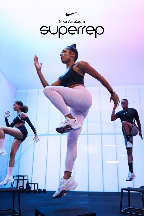 a woman in white tights and black top doing a trick on a stage with other dancers