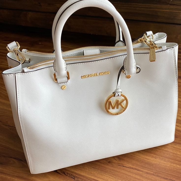 Mk Handbag, Excellent Condition, See Pictures For Details. 100% Authentic. Beautiful Clean White With Gold Details. This Was My Moms Bag And It Needs A Good Home! Gray Bag Also Available As Well As Other Mk Bags, Please Check Them Out! Feel Free To Ask Questions And Offers Welcome! Luxury White Satchel For On-the-go, White On-the-go Bags, Luxury White Shoulder Bag For On-the-go, White Shopping Bag With Gold-tone Hardware, White Shopping Bags With Gold-tone Hardware, White Satchel With Dust Bag For On-the-go, Designer White Bag For On-the-go, Designer White Satchel For Errands, White Top Handle Bag With Gold-tone Hardware