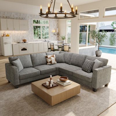 a living room filled with furniture next to a swimming pool in a home's open floor plan