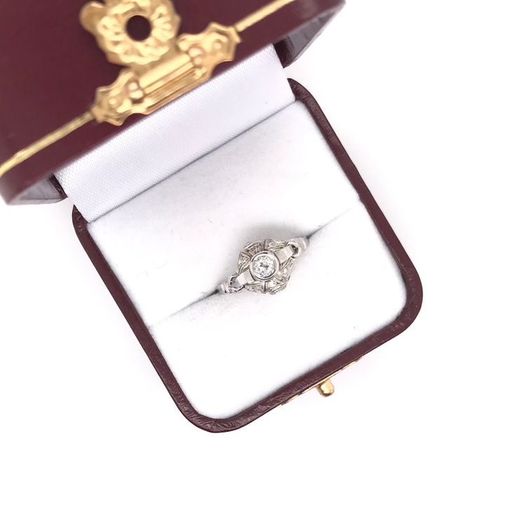 This sweet antique ring was crafted sometime during the Art Deco design period ( 1920-1940 ). The setting is 18k white gold and features a center bezel set diamond measuring approximately 0.25 carats. The setting features charming details such as four small sparkling diamond accents, extensive fine milgrain accents, and decorative hand engravings. This sweet and simple antique ring would make a  wonderful gift for almost any occasion. This ring is currently a size 7 & 1/2. Sizing available upon request. Item number VA8EF9 25 Carat Diamond Ring, Antique Ring, Sparkling Diamond, Bezel Set Diamond, Art Deco Design, Sparkle Diamonds, Antique Rings, Hand Engraving, Diamond Ring