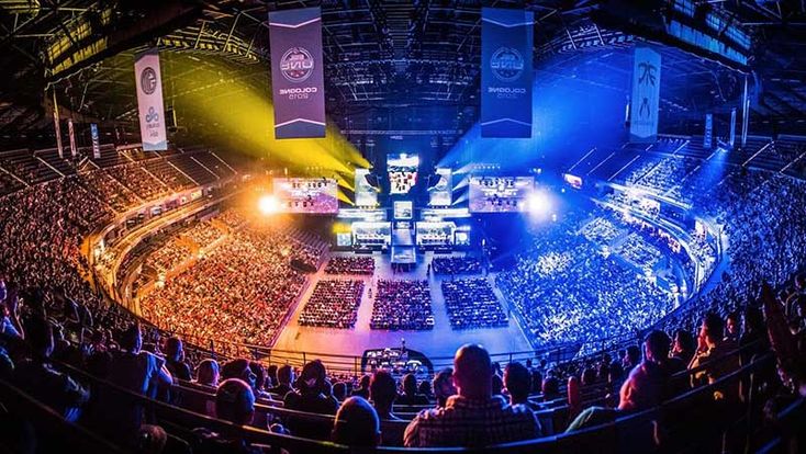 an arena with many people in it and lights on the sides of the auditoriums