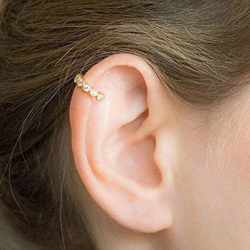 a close up of a person's ear with a small gold ring on it